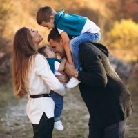 Young family with two sons together outside the park